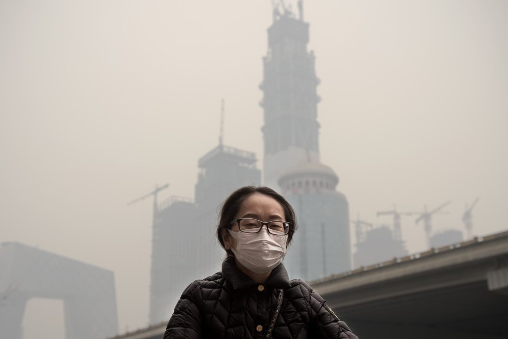 A file picture of a woman cycling in heavy smog in Beijing. Photo: Agence France-Presse