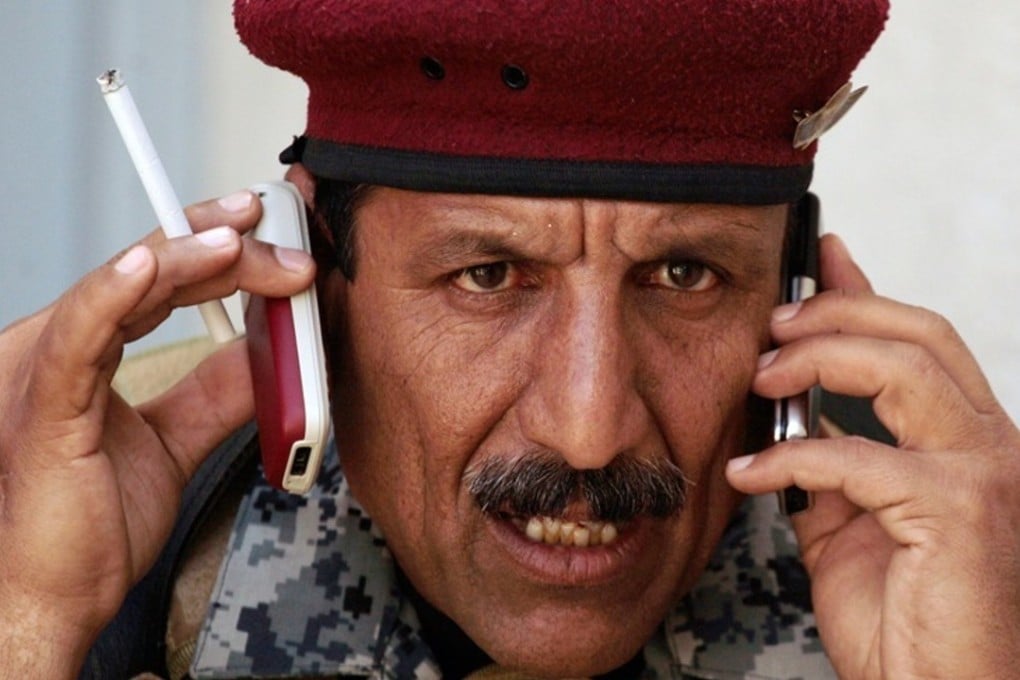 An Iraqi soldier talks on two cellphones at once in Mosul in 2009. Photo: AP