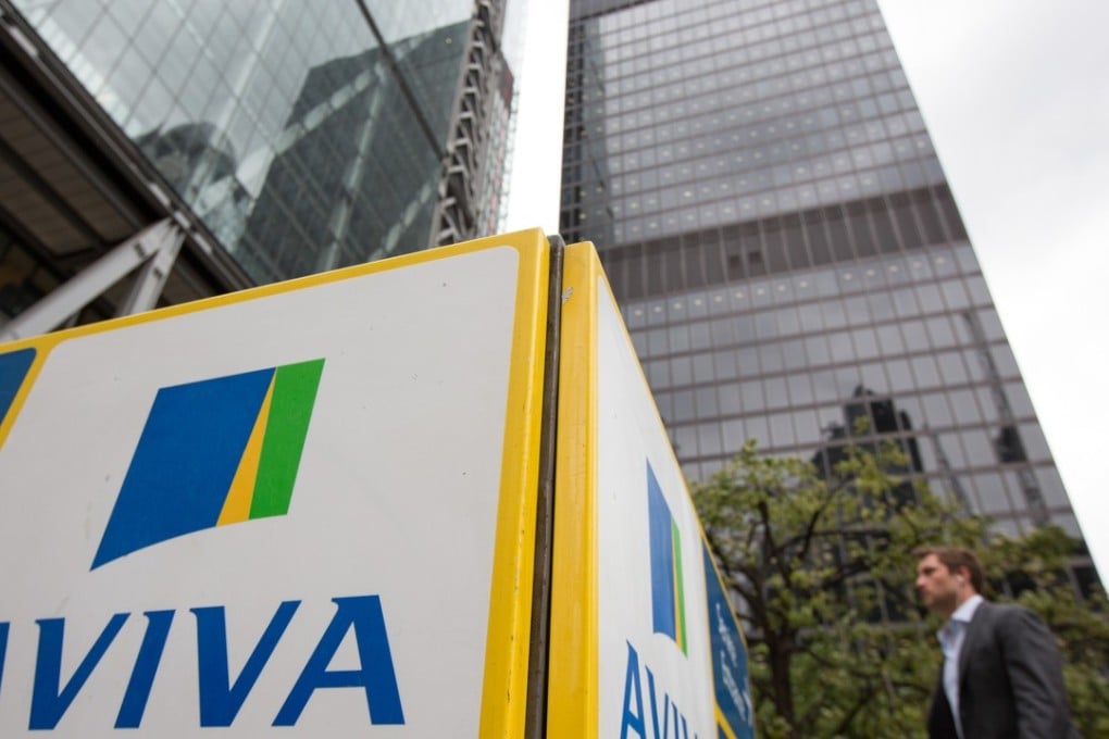 A pedestrian walks near to an Aviva Plc logo on a sign outside the insurance company's headquarters in London, U.K., on Monday, Aug. 1, 2016. Aviva will release their half-year results on Aug 4. Photographer: Jason Alden/Bloomberg