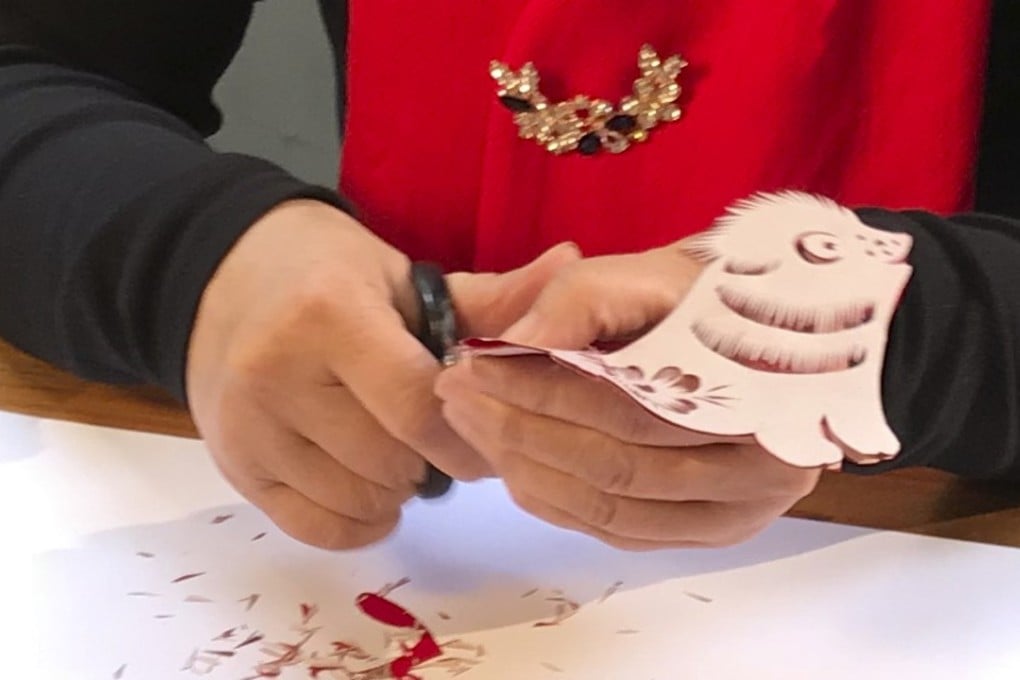 Master paper cutter Li Yunxia cutting out a shape of a dog to celebrate the upcoming Year of the Dog. Photo: Bernice Chan