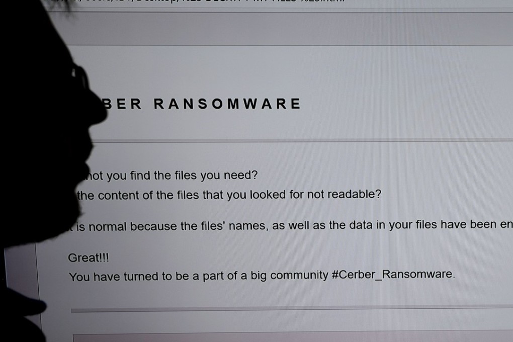 An IT researcher stands next to a giant screen of a computer infected by ransomware. Britain’s defence minister has accused the Russian government of “undermining democracy” with a cyberattack that targeted Ukraine and spread across Europe last year. Photo: AFP