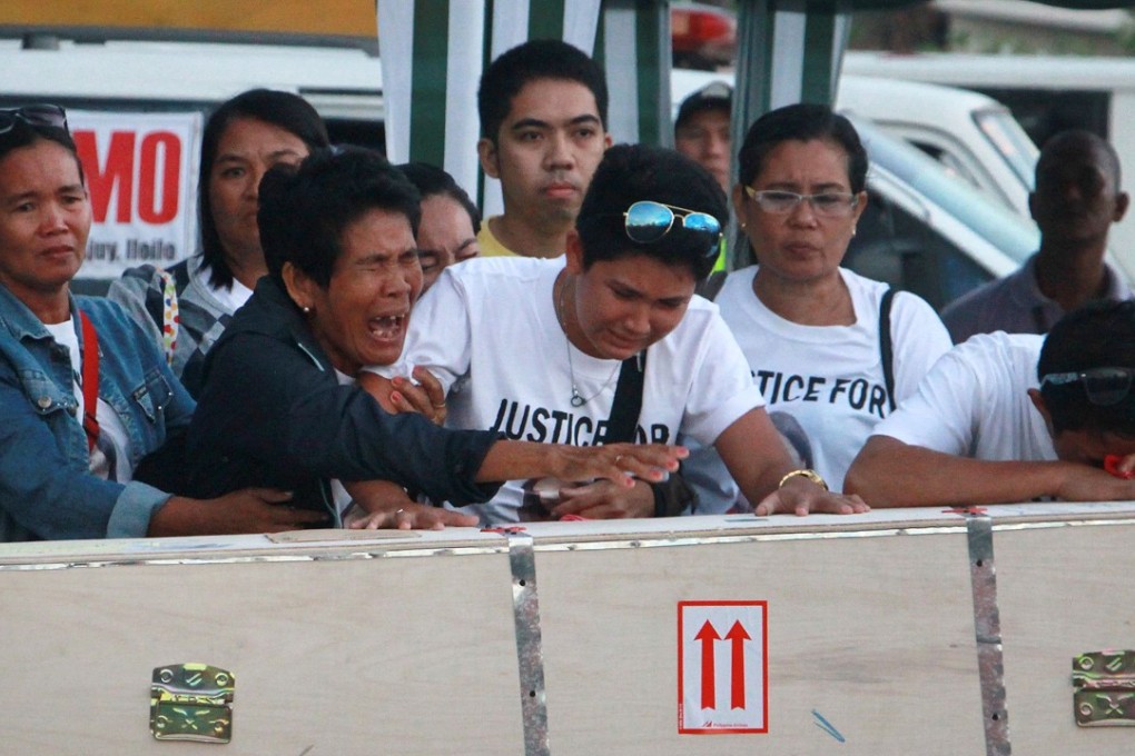 Eva (second left), mother of Filipino worker Joanna Demafelis, cries in front of the wooden casket containing her daughter’s body after it arrives at Iloilo International Airport. Photo: AFP