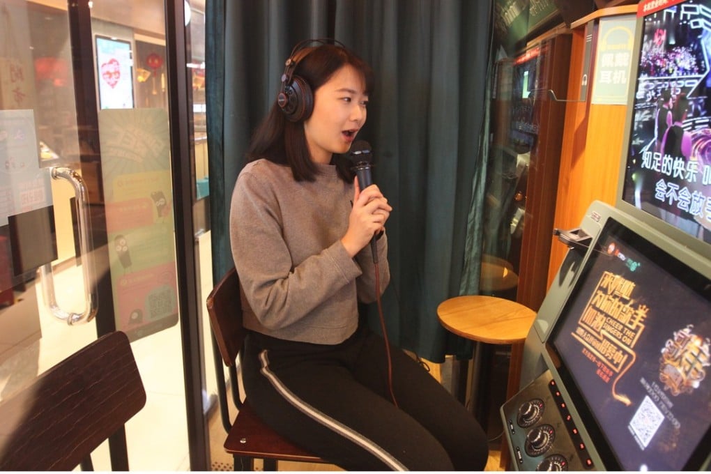 Jodie Zhou sings a song at a mini Karaoke box in a shopping centre in Beijing. Photo: Simon Song