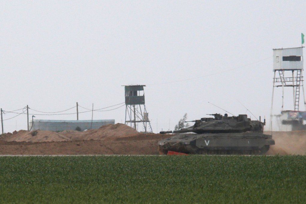 An Israeli tank manoeuvres along the border fence with the southern Gaza Strip, as watchtowers are seen on the Palestinian side near Kibbutz Nirim, Israel on February 17, 2018. Photo: Reuters