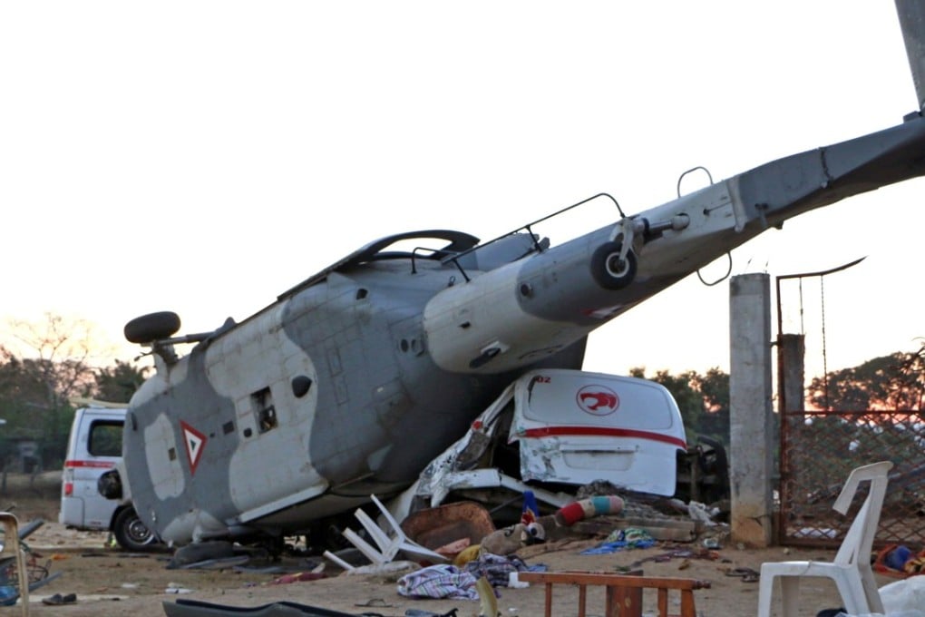 The remains of the military helicopter that fell on the vans. Photo: AFP