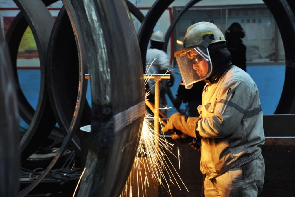 A worker cuts steel in Qingdao in China's eastern Shandong province. The country’s National Development and Reform Commission says it will encourage overseas investments that can boost China’s technological development and manufacturing competency. Photo: AFP