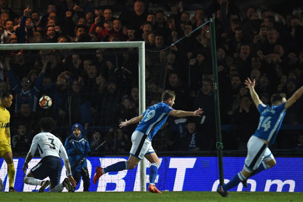 Rochdale’s Steven Davies (C) celebrates arms aloft with teammates after scoring his side’s late equalising goal during the FA Cup fifth round match against Tottenham Hotspur at the Crown Oil Arena in Rochdale. Photo: AFP