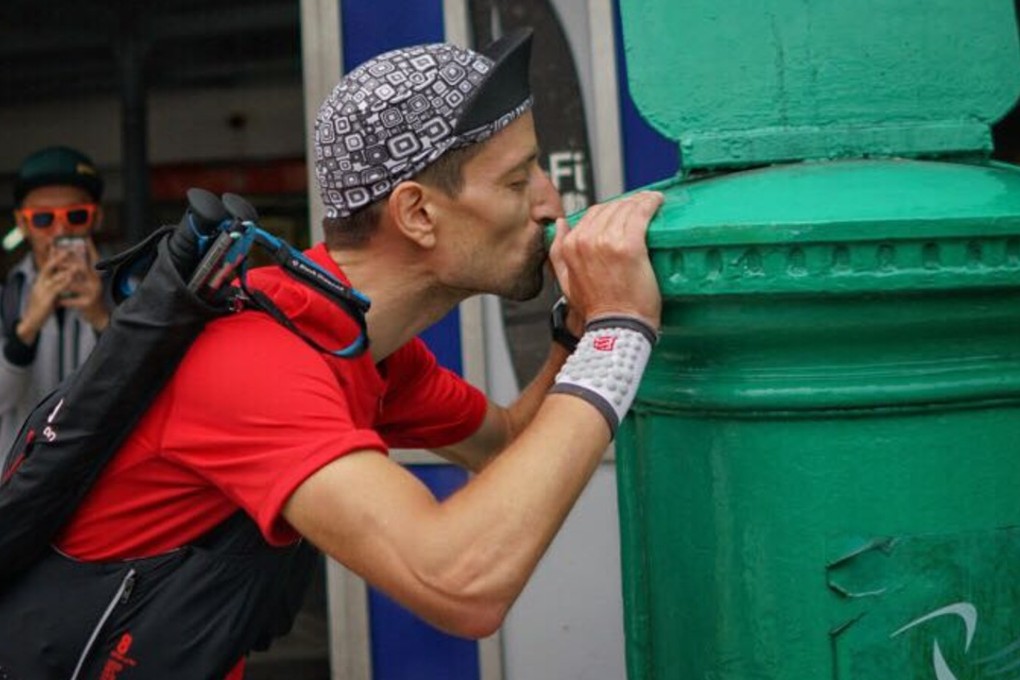 Salomon Wettstein kisses the postbox in Mui Wo after becoming the first ‘finisher’ in this year’s Four Trails Ultra Challenge. Photos: Lloyd Belcher Visuals