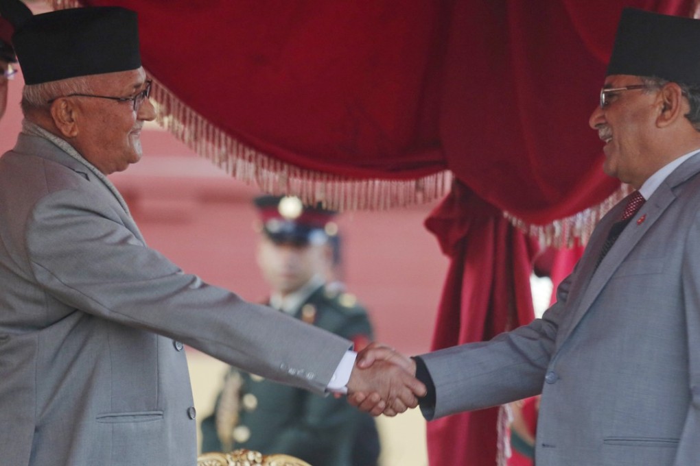 Nepal's new Prime Minister Khadga Prasad Oli, left, shakes hand with the chairman of Communist Party of Nepal (Maoist Centre) Pushpa Kamal Dahal after taking the oath of office. Photo: AP