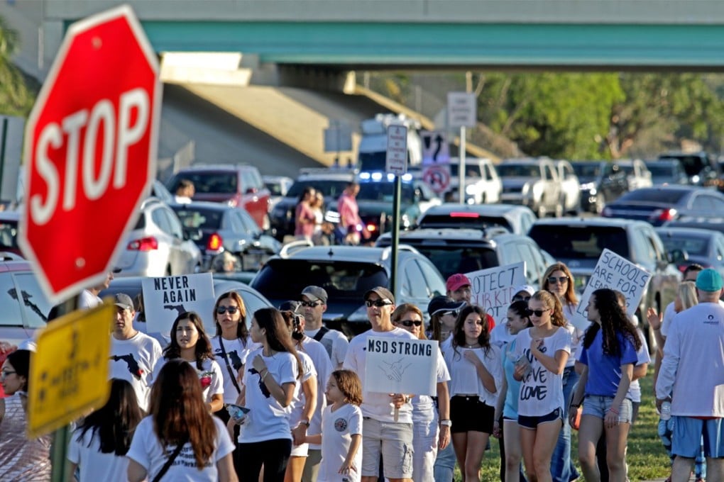 A large group of protesters walk toward Marjory Stoneman Douglas High School in Parkland, Florida, on Sunday. More protests are planned for next month. Photo: Sun Sentinel via TNS