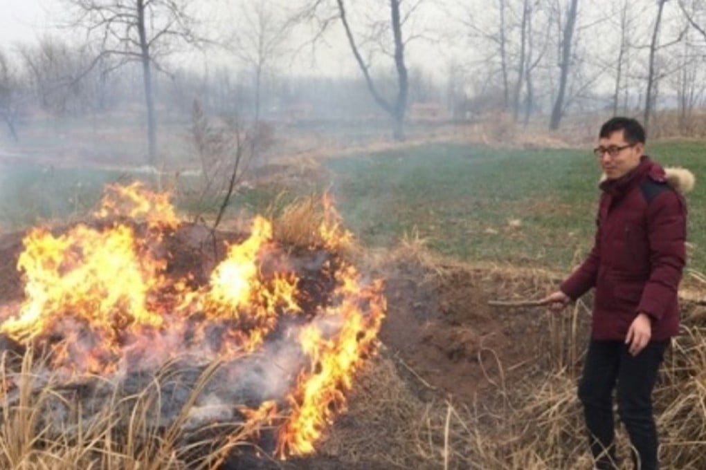 One of the men stokes a blaze after deliberately lighting a fire in the field. Photo: Guancha.cn