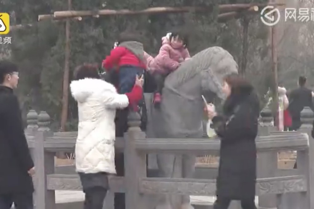 Parents help their children climb on the statues. Photo: 163.com