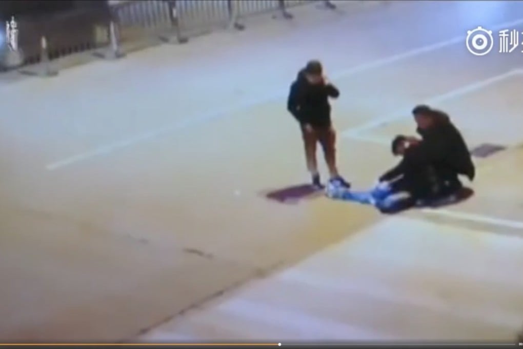 The man shown in video footage slumped on the ground, supported by a friend. Photo: Weibo