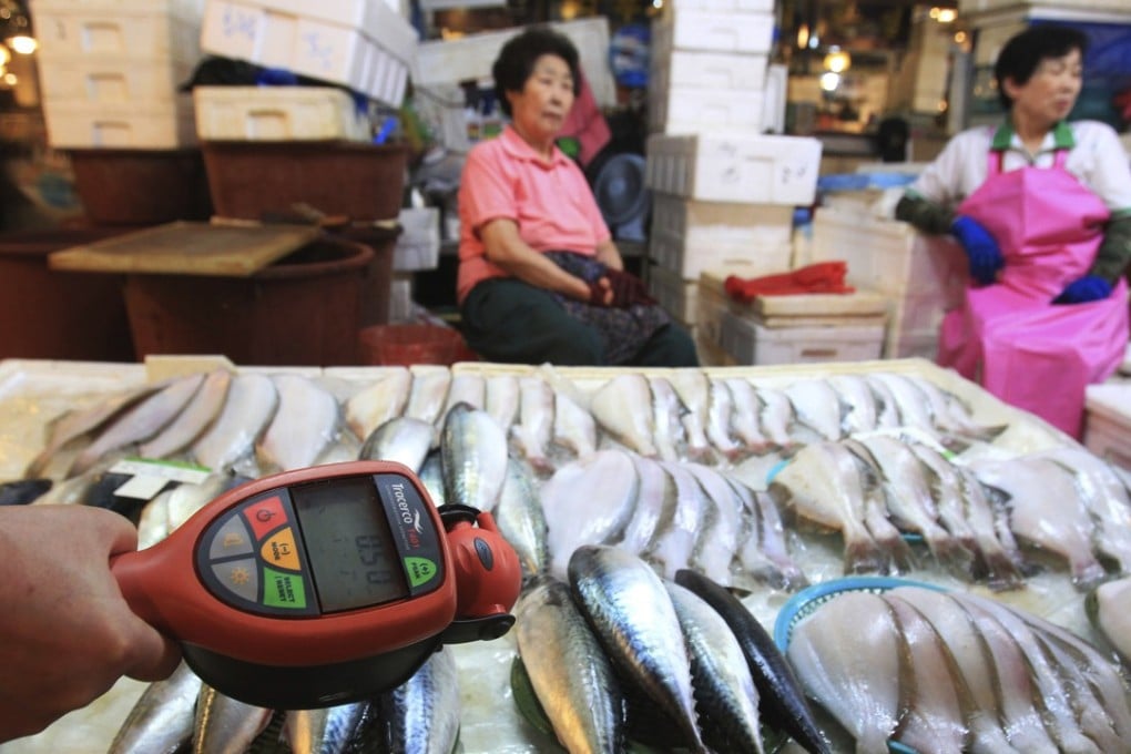 A worker using a Geiger counter checks for possible radioactive contamination at Noryangjin Fisheries Wholesale Market in Seoul, South Korea. Photo: AP