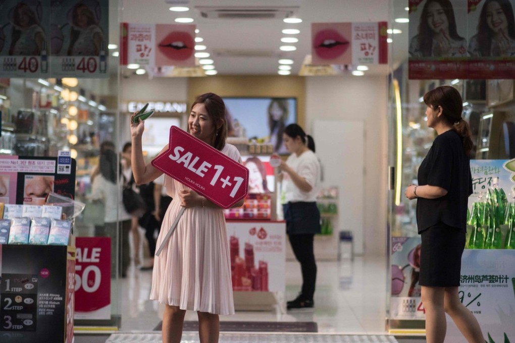South Korean cosmetics and beauty products remain popular with mainland consumers in spite of calls from some groups for boycott. A salesperson in front of a cosmetics store in the popular Myeongdong shopping area of Seoul. Photo: AFP