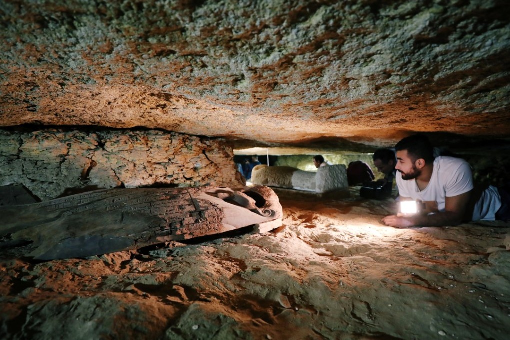 An Egyptian antiquities worker is seen inside the recently discovered burial site in Minya, Egypt. Photo: Reuters