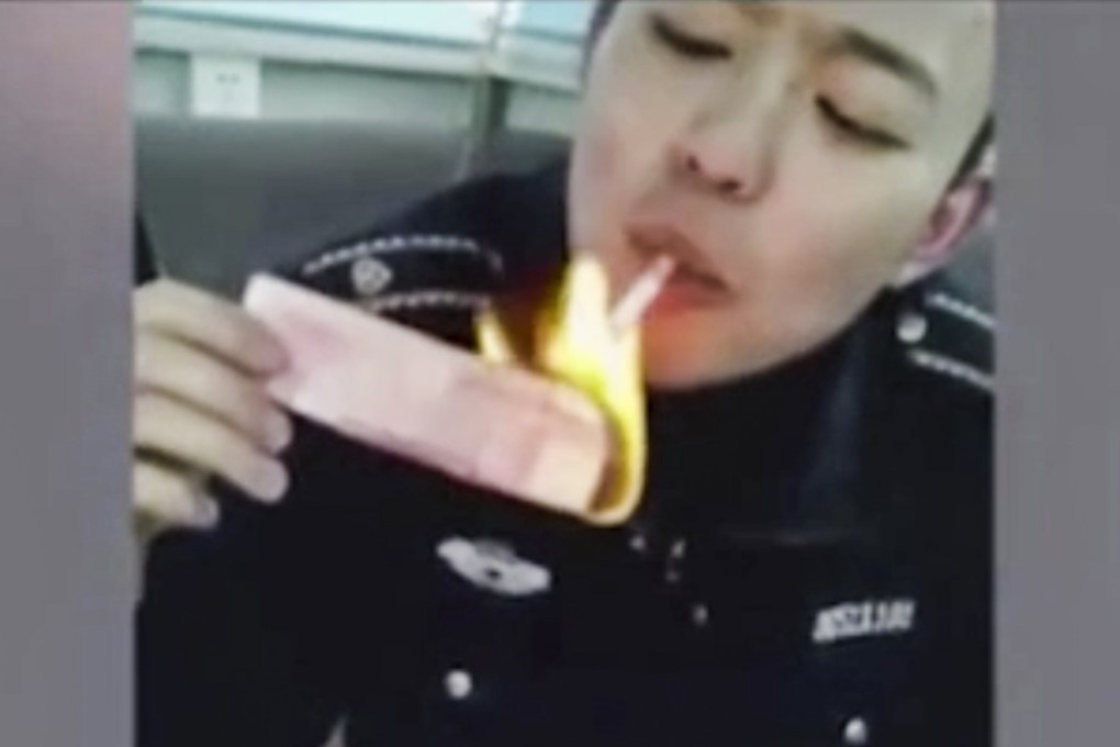 A still from the video of an urban inspector setting a fake 100 yuan note on fire and using it to light a cigarette. Photo: News.163.com