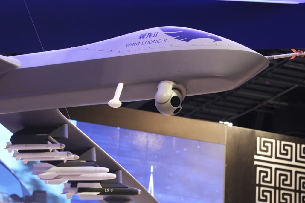 A model of a Wing Loong II weaponised drone hangs above the stand for the China National Aero-Technology Import and Export Corp at a military drone conference in Abu Dhabi. Photo: AP
