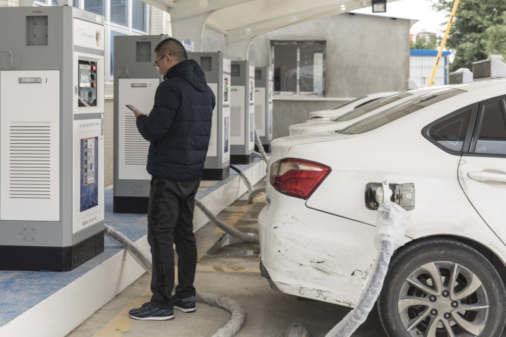 A driver charges an electric taxi at a charging station in Ningde, Fujian province. Photo: Bloomberg