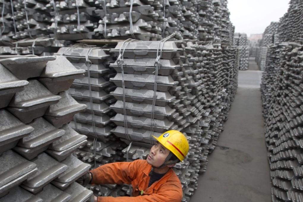 An employee checks aluminium ingots for export at Qingdao Port in Shandong province on March 14, 2010. Photo: Reuters