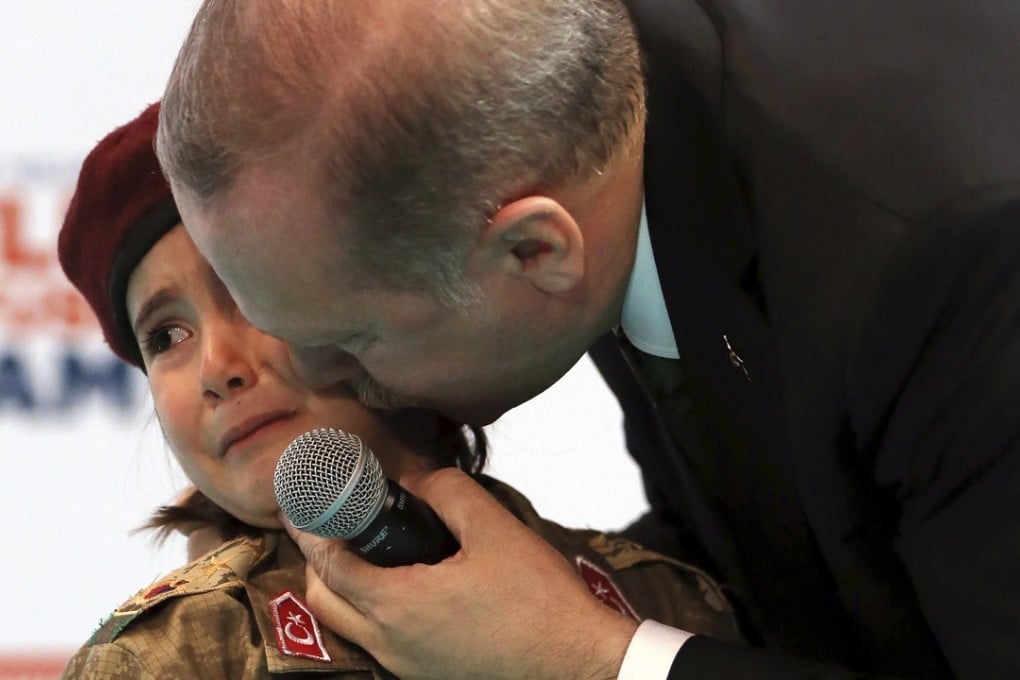 Turkish President Recep Tayyip Erdogan kisses Amine Tiras, a weeping girl in military uniform, as he speaks to his ruling party members, in Kahramanmaras, Turkey, on Saturday. Photo: AP