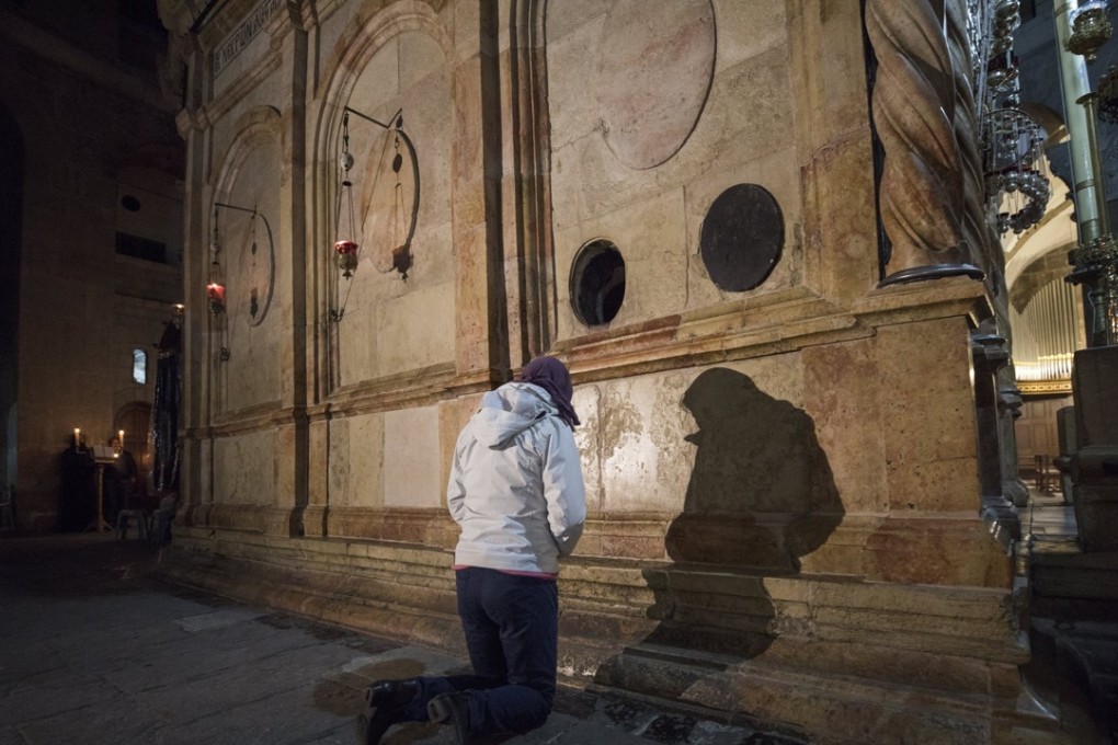 A Christian devotee prays at the Church of the Holy Sepulchre after it reopened. Photo: EPA