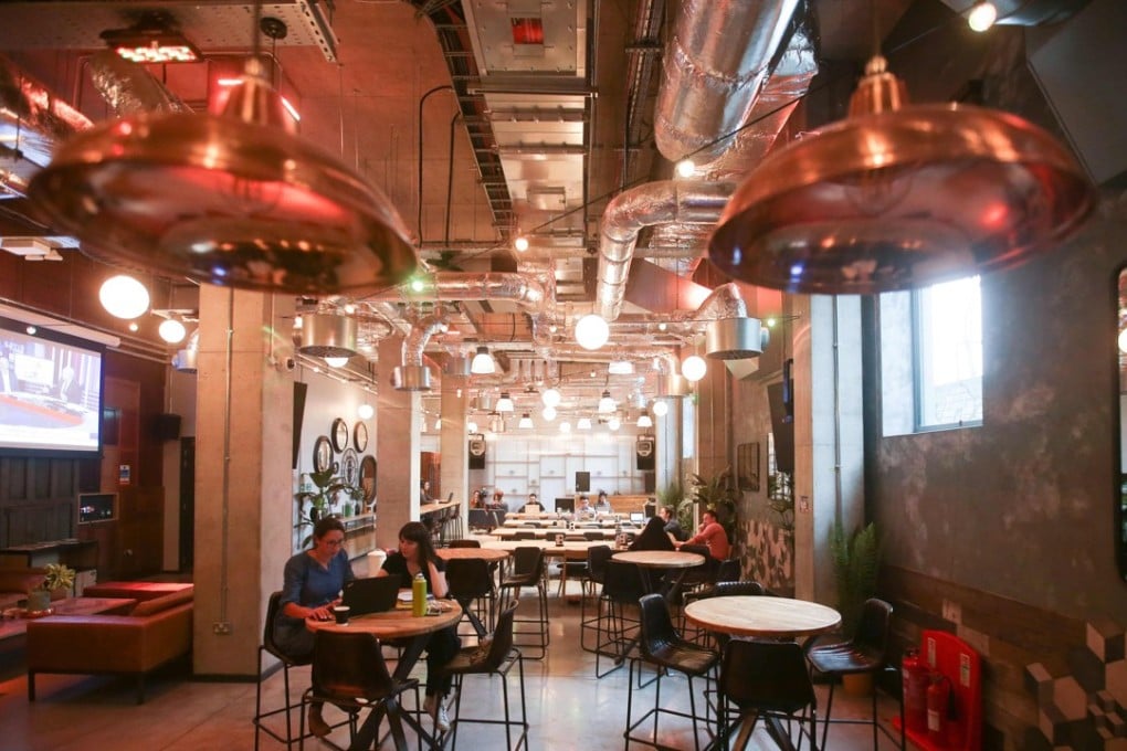 Residents work in one of the communal spaces at a co-living building in London in October 2017. The 10-storey building looks like a hotel, but it is actually a large-scale house-share offering modest rooms and upscale services for young adults caught in London's housing crisis. Photo: AFP