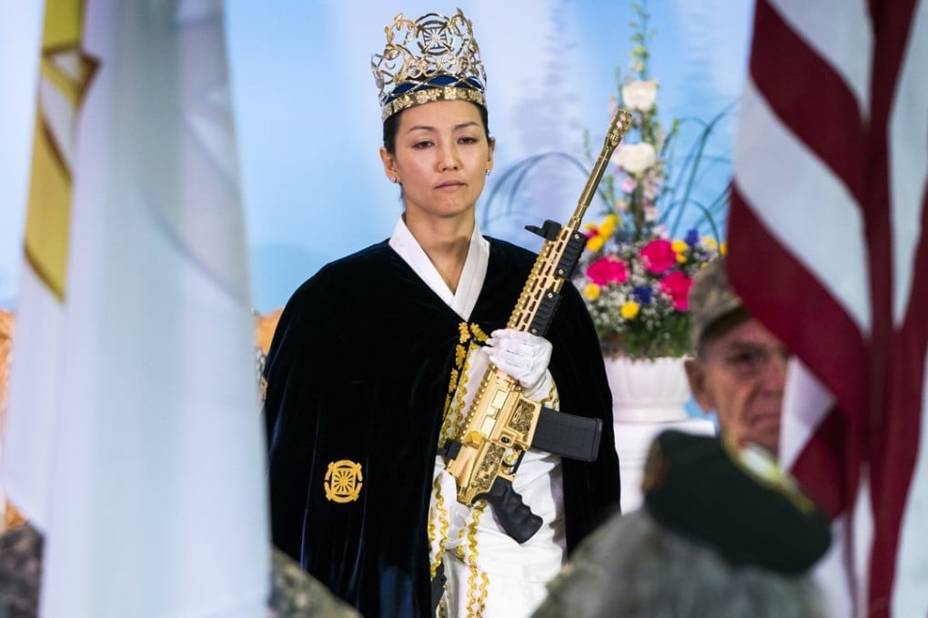 Reverend Yeon Ah Lee-moon of the Sanctuary Church holds a gold AR-15 during a ceremony to rededicate marriages at the World Peace and Unification Sanctuary in Newfoundland, Pennsylvania, on Wednesday. Photo: EPA-EFE