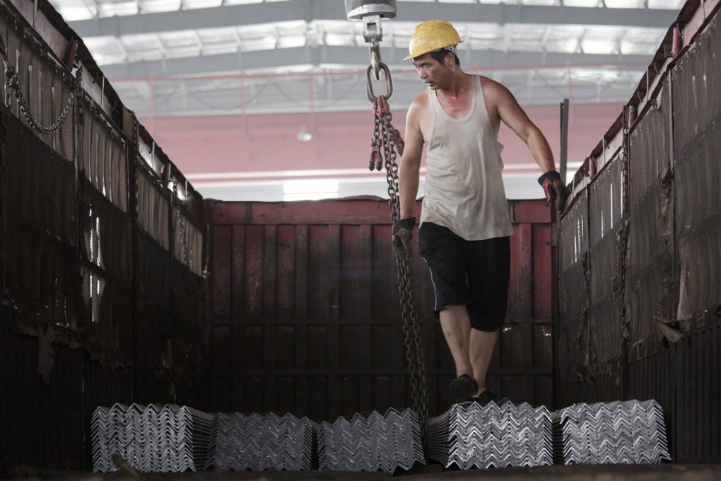 A worker helps load steel bars onto a truck at warehouse of the Baifeng Iron and Steel Corporation in Tangshan, Hebei province, in this file photo. Photo: Reuters