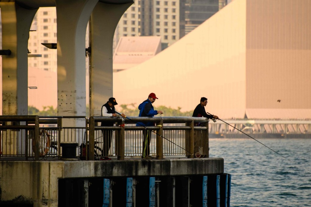 Anglers fish from a pier in Hong Kong’s Victoria Harbour, on February 28. According to an opinion poll, Hongkongers gave the budget a dissatisfaction rating that is the highest in the past four years. Photo: AFP