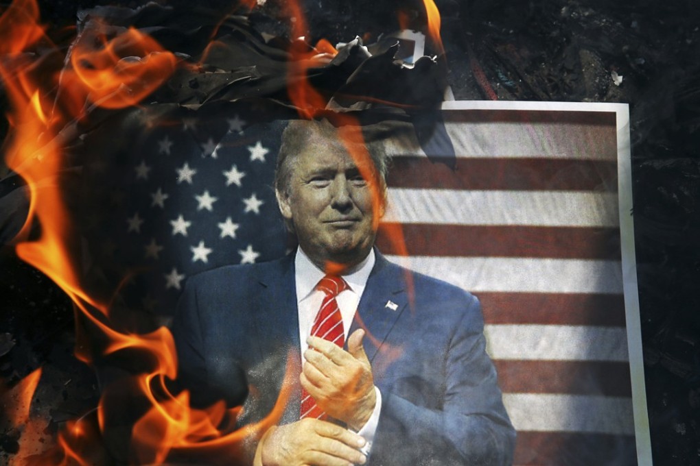 A portrait of US President Donald Trump is set on fire by Iranian mourners during a state funeral for a young Revolutionary Guard soldier beheaded by Islamic State in Syria, in Tehran last September 27. Photo: AP