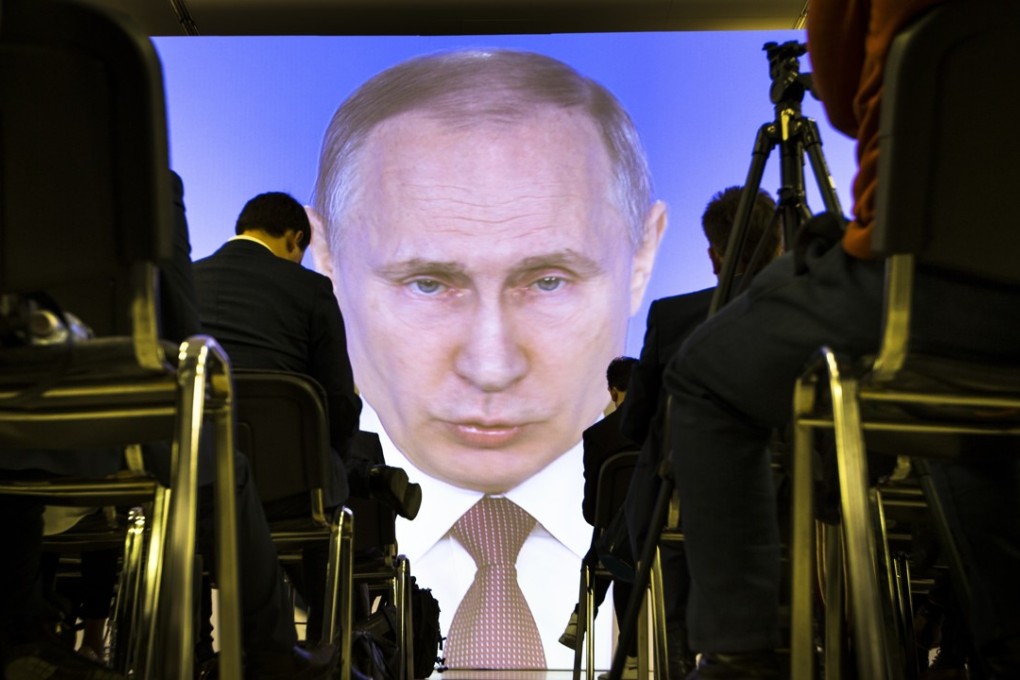 Journalists watch as Russian President Vladimir Putin gives his annual state of the nation address. Photo: AP