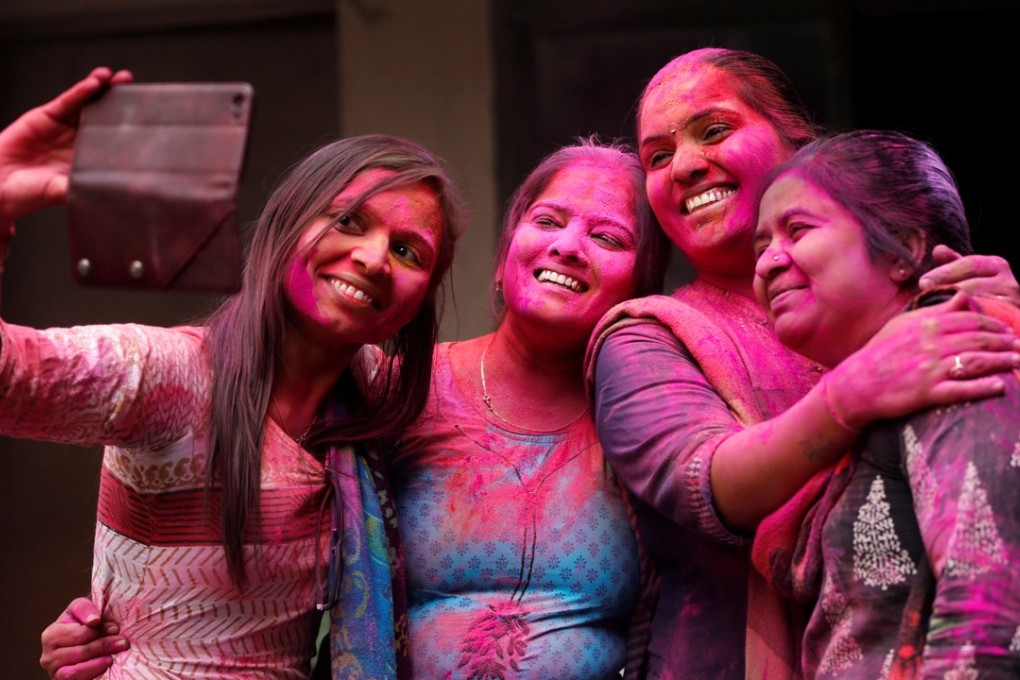 Indian teachers smeared with coloured powder take a selfie during Holi celebrations at a school in Ahmadabad on Thursday. Photo: Reuters