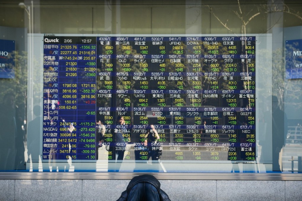A man reacts after looking at an electronic stock board in Tokyo, Japan, on February 6 after stock markets around the world plunged. The financial forecast for 2018 is hard to read and is likely to hinge on central bank policy. Photo: Bloomberg