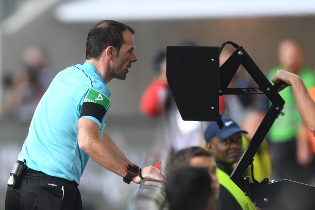 Referee Marco Fritz checking the video assistant referee (VAR) during the German Bundesliga match between FC Augsburg and Borussia Dortmund. Photo: AFP