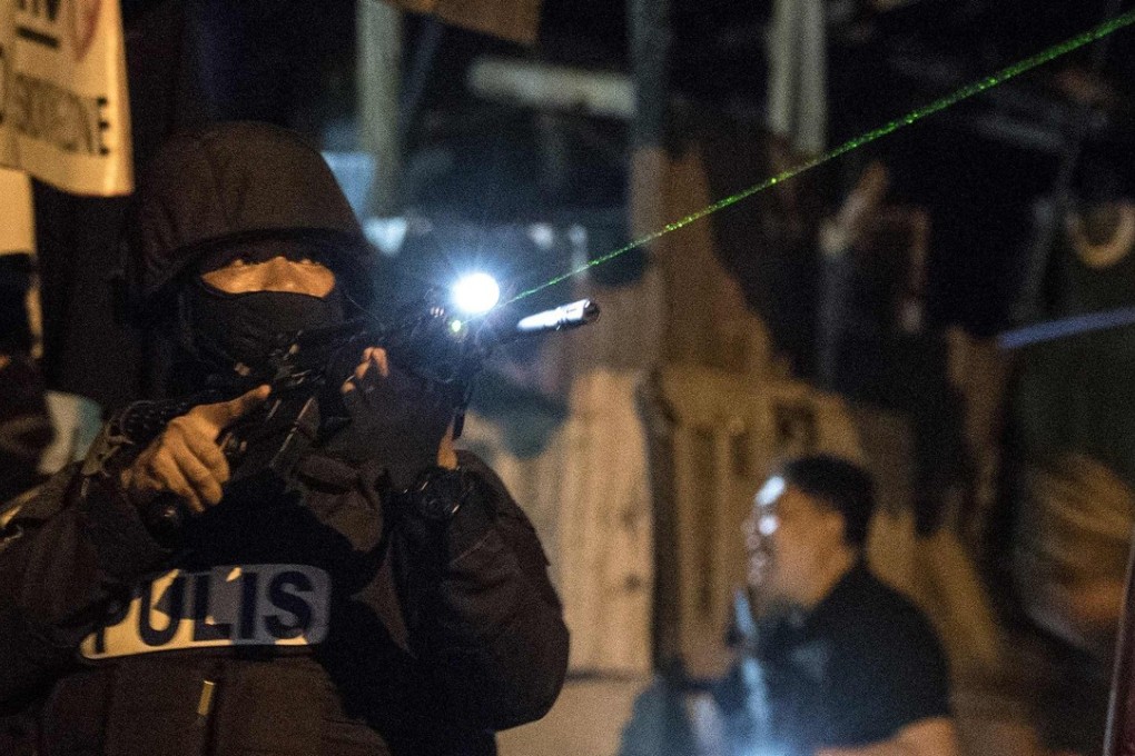 Officers from the Philippine Drug Enforcement Agency search a house during a drug raid south of Manila. More than 100 suspects have died since President Duterte’s drug war restarted in December. Photo: AFP