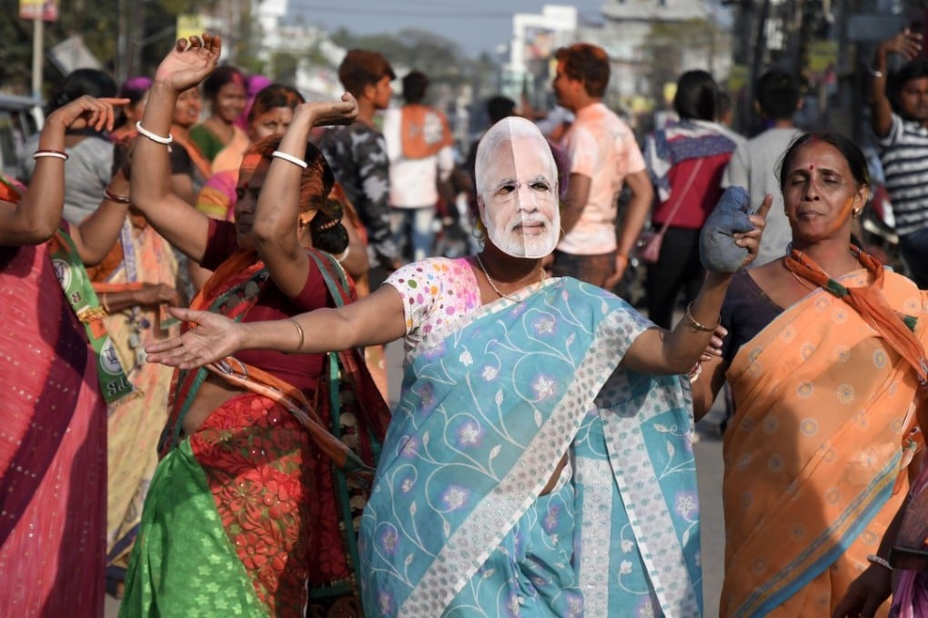 A BJP supporter wearing a Narendra Modi mask celebrates after victory against the Communist Party of India (Marxist) in Tripura state. Photo: EPA