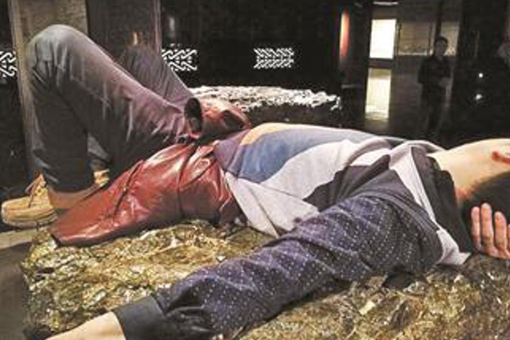 A visitor to the Sanxingdui Museum in southwestern China’s Sichuan province used a large slab of raw jade as a daybed and would not budge until his wife scolded him. Photo: Sina