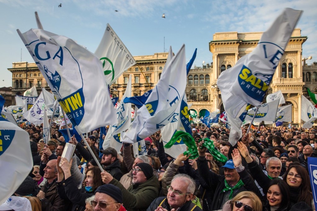 Attendees wave flags and gather during an election campaign rally for The League party at Duomo Square in Milan on Saturday, February 24, 2018. Matteo Salvini, leader of the Euro-sceptic League, said Italians must not be slaves of Berlin or Brussels and pledged to change European Union rules that hinder the country's economic growth if his party wins power in the March 4 election. Photo: Bloomberg