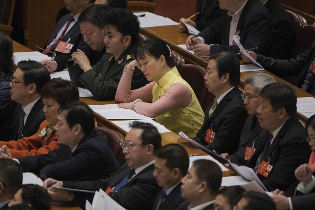 A delegate dozes off during the opening session of the CPPCC in Beijing on Saturday. Photo: AFP