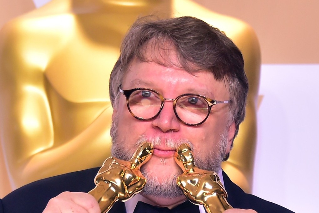 Director Guillermo del Toro poses in the press room with the Oscars for best picture and best director. Photo: AFP