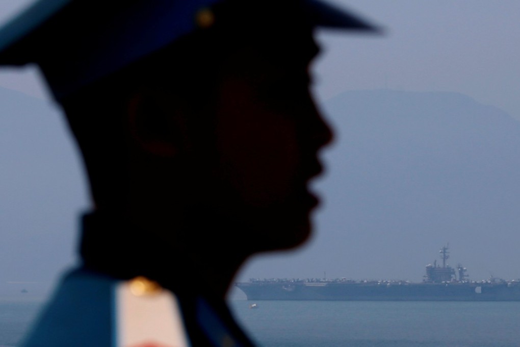 A Vietnamese soldier keeps watch as aircraft carrier USS Carl Vinson arrives at a port in Da Nang. Photo: Reuters