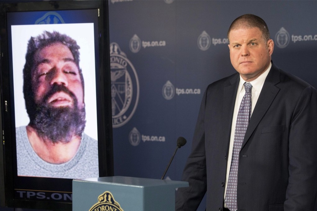 Hank Idsinga, lead investigator in the case against Bruce McArthur, stands with a photo of an unidentified man, left, during a news conference at Toronto Police headquarters on Monday. Photo: AP