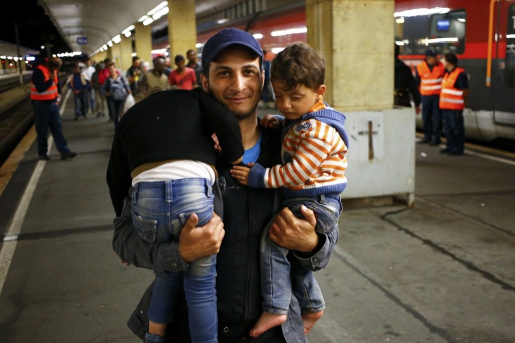 A newly arrived migrant carries his children at the railway station in Vienna, Austria, in this 2015 file photo. Photo: Reuters