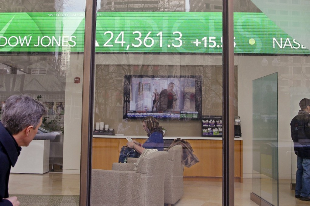 A passer-by peers in the window, while investors congregate inside at the Fidelity Investments office as the ticker displays stock market numbers. Over the last 10 years, passive indexing has crowded out active managers without any reversal in sight. Perhaps, suggests Peter Guy, recent market events and fund industry changes will revive active managers. Photo: AP