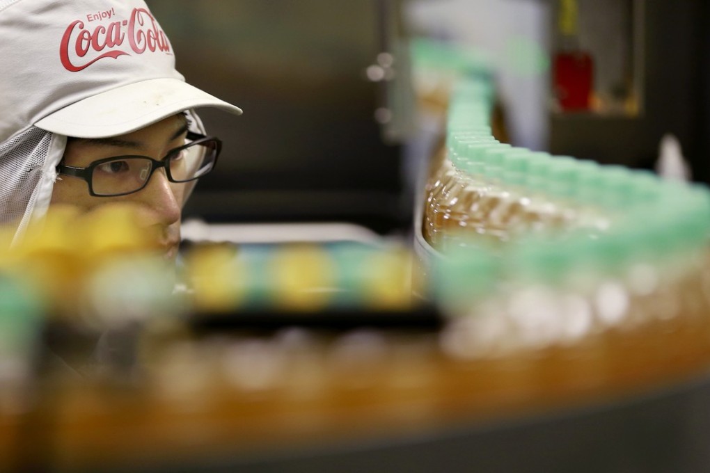 A worker watches a product line at Coca-Cola Ebina plant in Ebina, Kanagawa Prefecture, near Tokyo. The soda maker, best known for Coke, Sprite and Fanta, says it’s experimenting with a canned beverage that would be a mix of sparkling water and an alcoholic Japanese drink. Photo: AP