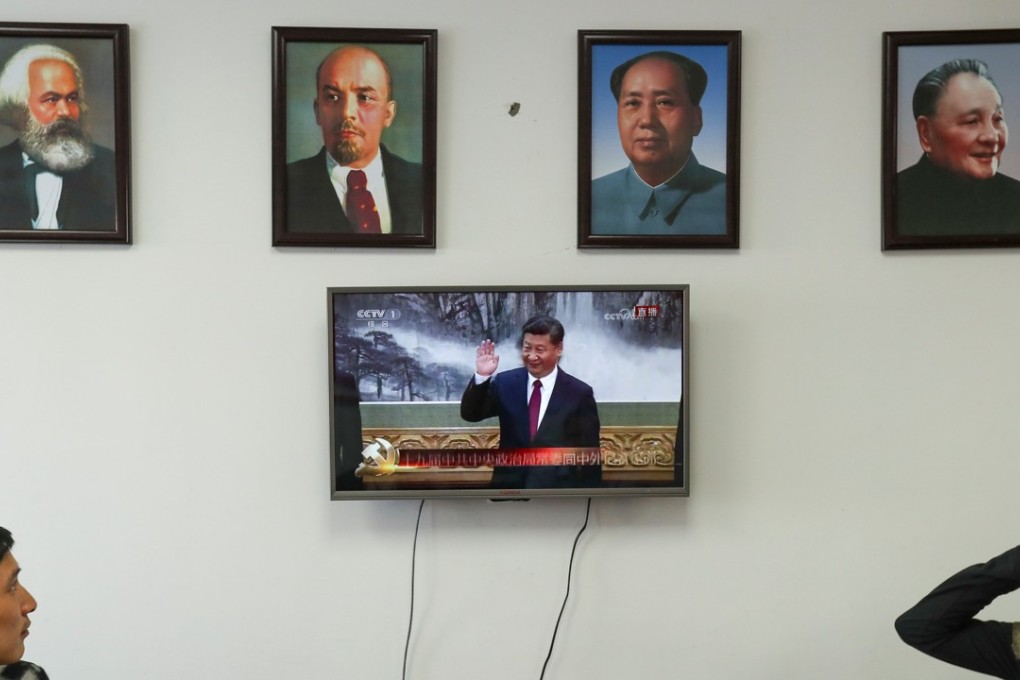 Framed portraits of German philosopher Karl Marx, Soviet state founder Vladimir Lenin and China’s late leaders Mao Zedong and Deng Xiaoping hang above a screen showing President Xi Jinping. Photo: Reuters