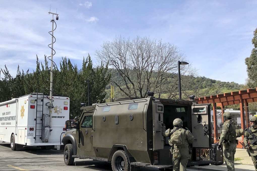 Law enforcement members stage near the Veterans Home of California after reports of an active shooter Friday, March 9, 2018, in Yountville, Calif. Napa County Fire captain Chase Beckman says a gunman has taken hostages at the veterans home in California. (JL Sousa/Napa Valley Register via AP)