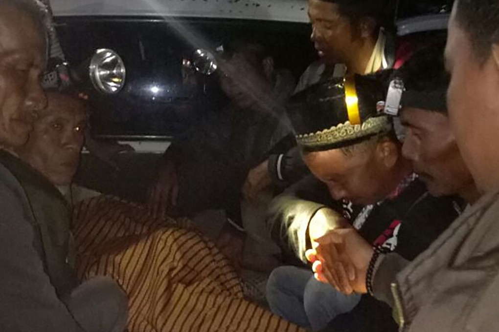 Mourning relatives sit on a pickup truck with the body of Yusri Effendi. Photo: AFP