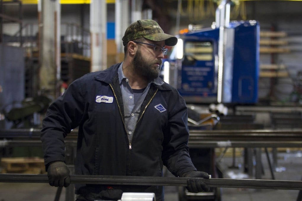 A factory worker carries bars of machine-grade steel in the Pacific Machinery & Tool Steel Company in Portland, US, on March 6. Photo: AFP
